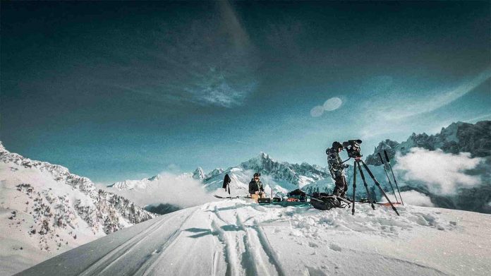 best ski films - guy with a camera filming group of people snow boarding and skiing